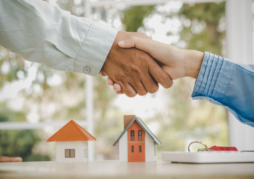 two-people-shaking-hands-with-small-homes