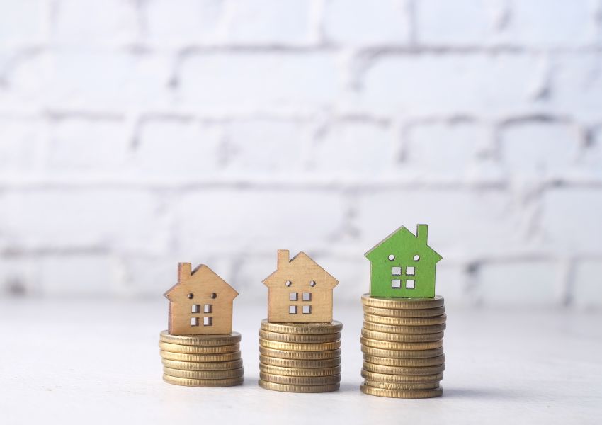 three-piles-of-coins-with-wooden-homes